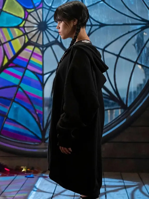 Side view of Jenna Ortega as Wednesday Addams, showcasing the oversized, black zippered hoodie