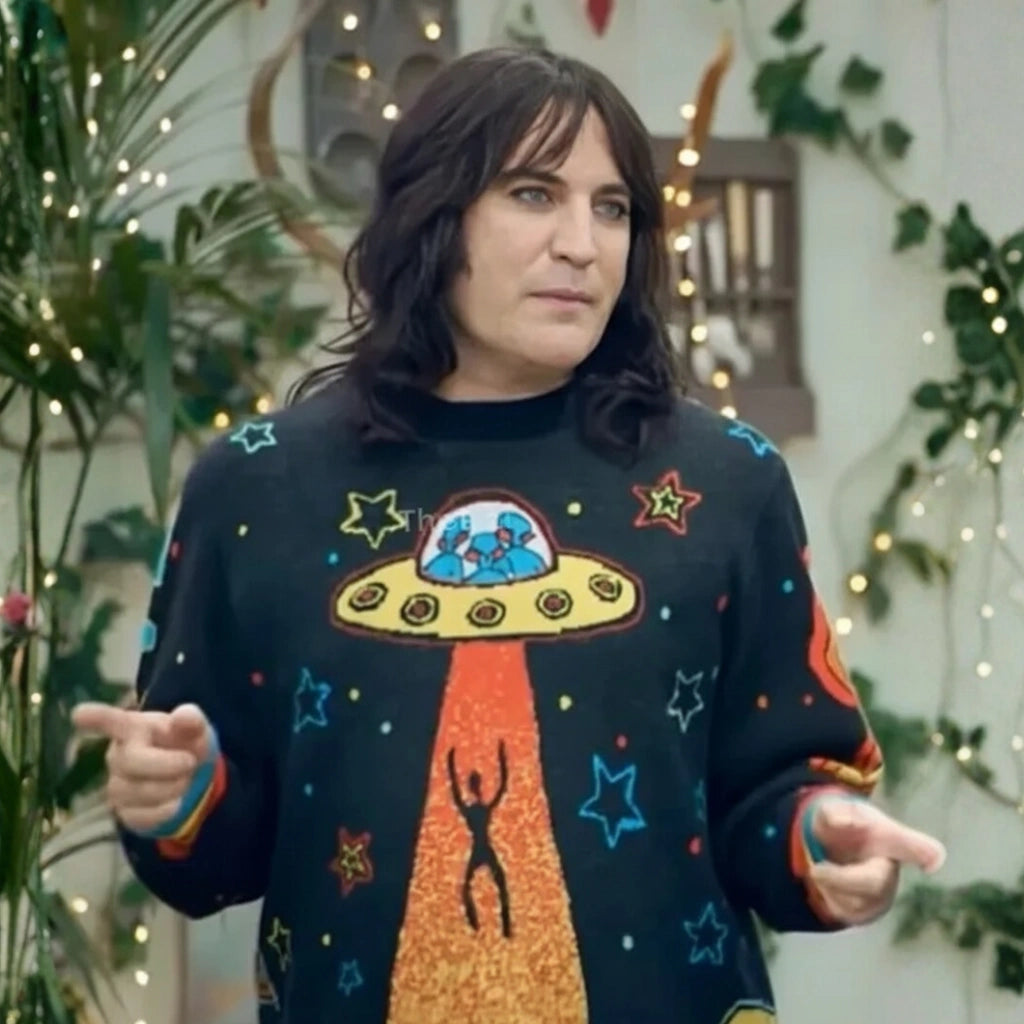 Person wearing a sweater with a UFO design in a decorated indoor setting