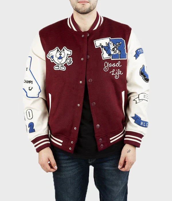 Man wearing a maroon and white True Religion Letterman Jacket with various patches on a plain background