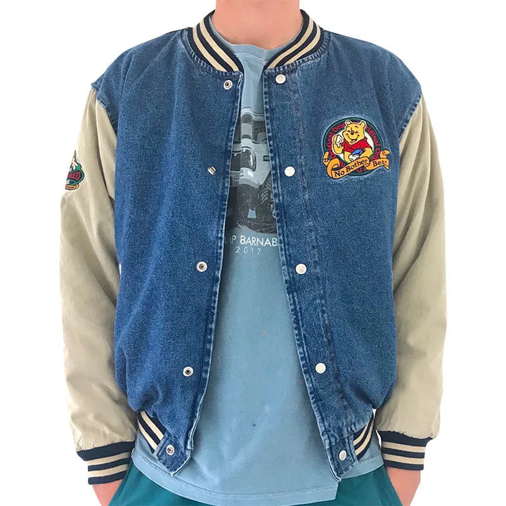 Blue and beige Winnie The Pooh Denim Jacket with a logo on a white background